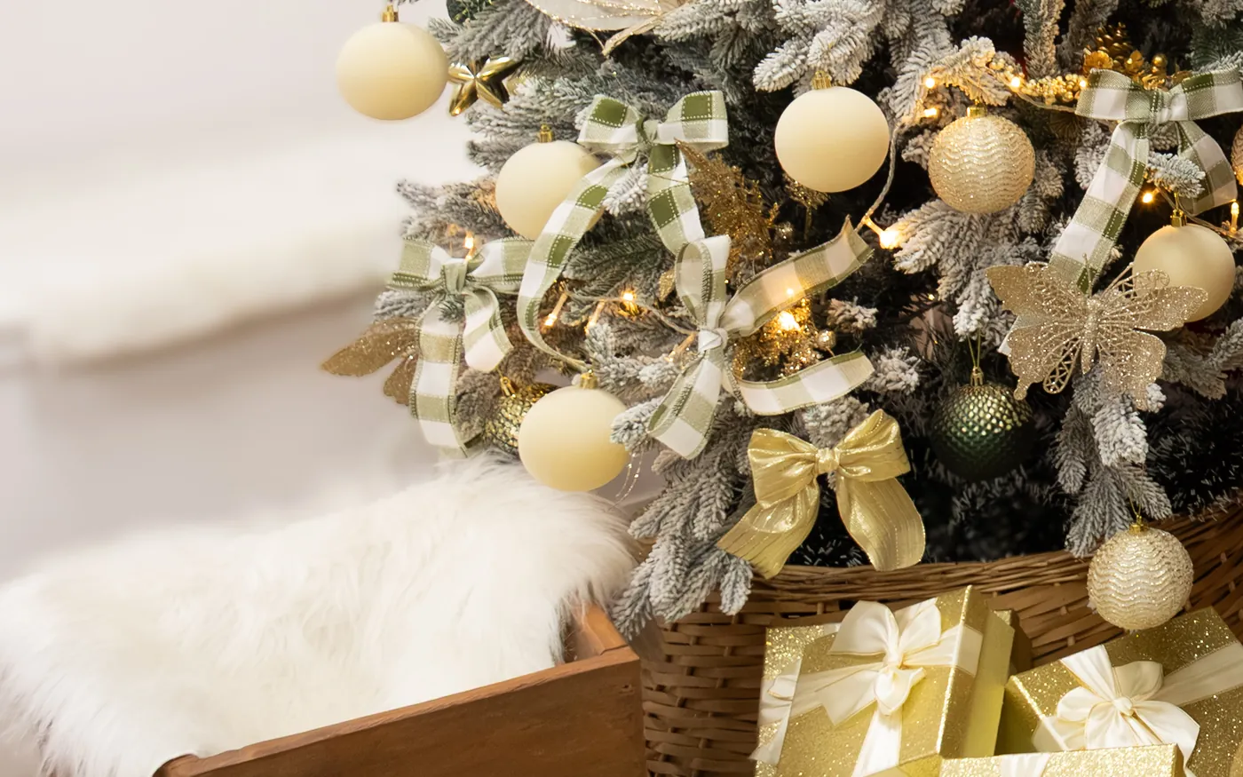Árvore de Natal com laços xadrez, bolas douradas e presentes no cenário do Nosso Estúdio