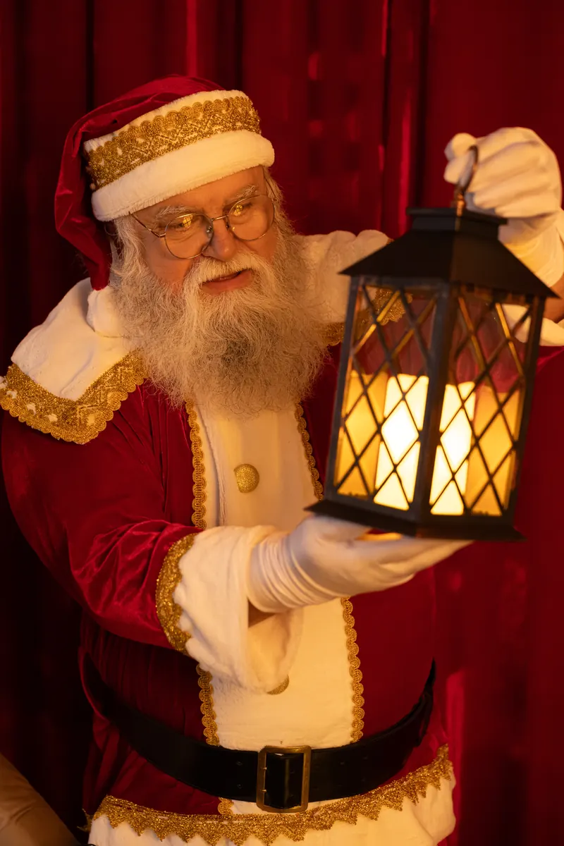 Papai Noel segurando uma lanterna acesa